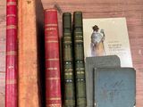 Plusieurs vieux livres sont posés sur une table en bois à côté d'un livre