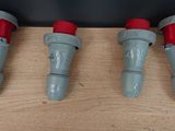 four red and gray water hoses are lined up on a wooden surface