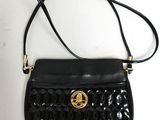 un petit sac à main noir orné d'un logo doré