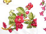 a white table cloth with red flowers and a butterfly on it