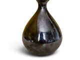 a black vase that is sitting on a white surface