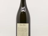 une bouteille de vin posée sur une table à côté d'un verre