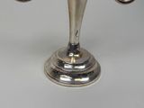 a silver candle holder with two candles on it