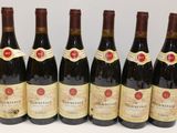 six bottles of wine are lined up in a row on a table
