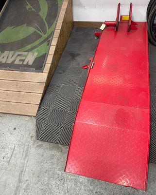 a red ramp that is next to a box with a tire