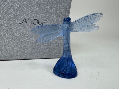 figurine en verre bleu d'une libellule avec une boîte en arrière-plan