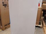 un réfrigérateur blanc posé sur une palette dans un entrepôt