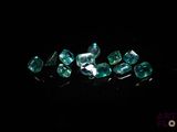 un gros plan sur un bouquet de diamants verts posés sur une surface noire