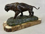 bronze sculpture of a lion on a rock on a white background