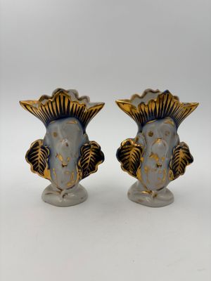pair of blue and gold vases with fish heads on them
