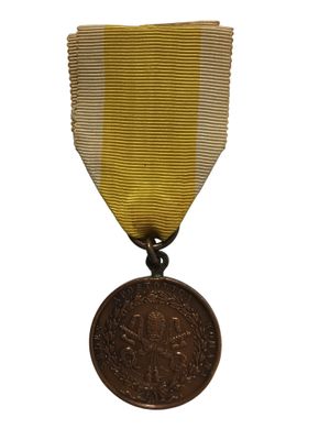 une vieille médaille ornée d'un ruban doré sur fond blanc