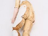 a doll that is laying on the ground with it ' s head on the ground