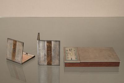 une table en verre sur laquelle se trouvent un livre et une horloge