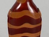 a brown and red vase with a yellow top on a table