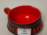 un bol rouge orné d'un motif noir et blanc
