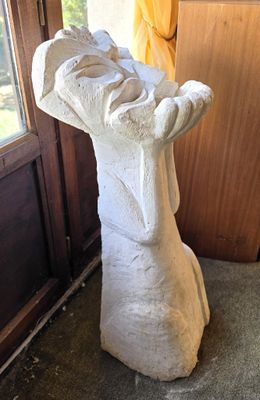 a statue of a dog that is sitting in front of a door