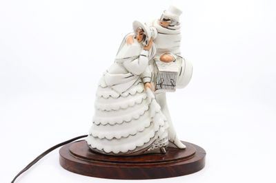 une figurine représentant un couple de jeunes mariés posée sur une table