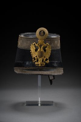 an officer ' s helmet with a gold eagle on the front