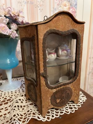une petite armoire en bois avec une porte vitrée, posée sur une table