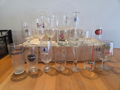bottles and glasses are lined up on a table in front of a wooden crate