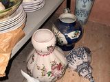several vases and plates on a shelf in a room with pink walls
