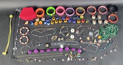 de nombreux bracelets et colliers de différentes couleurs disposés sur une table