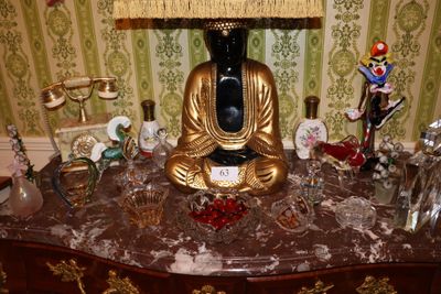 une statue de Bouddha assis sur une table sur laquelle se trouve une lampe