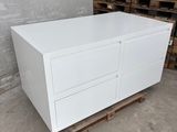 an image of a white chest of drawers in a warehouse