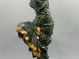 une statue représentant une femme en robe verte, posée sur un socle