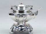 a silver plated teapot on a stand with a lid