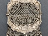 a silver purse with a chain hanging from it ' s side