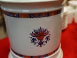 a white vase with a blue and orange design on it