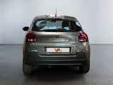 the back of a silver car is parked in a large room