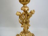 un bougeoir doré surmonté d'une statuette