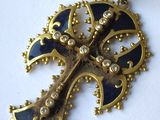 une image représentant un pendentif en forme de croix dorée et bleue sur un fond blanc
