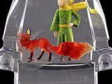 a toy figurine of a boy and a fox in a glass bowl