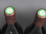 four bottles of wine are lined up in a row