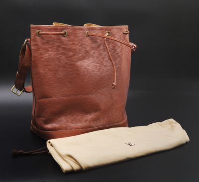 une image représentant un sac à main et un tissu posés sur une surface noire