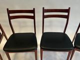 four chairs are lined up in a row on a white surface