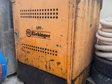 a yellow machine sitting on top of a building next to a pile of tires