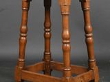 an old wooden stool with turned legs and a wooden seat