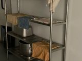 a metal shelf with a pot and pans on it