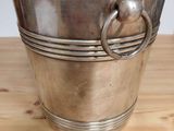 silver plated ice bucket with handles on a wooden table