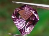 quelqu'un tient une paire de pinces ornées d'un diamant violet