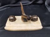 une sculpture en bois représentant un oiseau posé sur un bloc de bois
