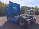 a blue truck that is parked in a lot
