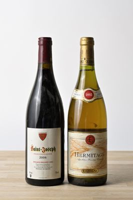 two bottles of wine sitting on top of a wooden table next to each other