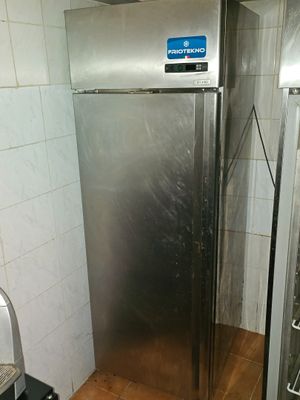 a stainless steel refrigerator in the corner of a kitchen