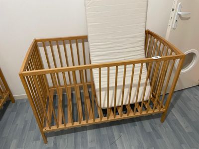 a baby crib with a mattress in the corner of the room