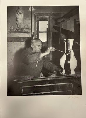black and white photograph of a man working on a sculpture